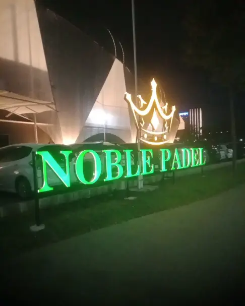 Noble Padel sign lit at night